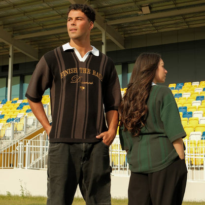 Two people standing in a stadium with yellow and blue seats wearing Owlam Apparel christian knit polo with text finish the race