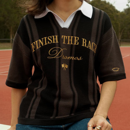 Person wearing a black and gold christian knit polo with text finish the race on a track background