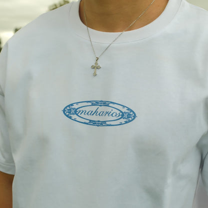 White t-shirt with blue 'makarios' logo worn by a person