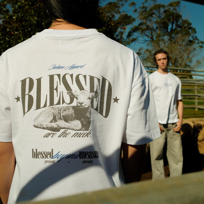 Person wearing a white t-shirt with 'BLESSED' graphic and text, standing outdoors.